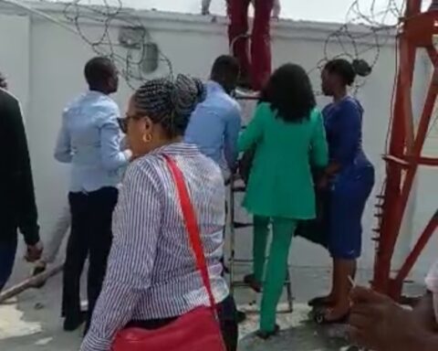 Naira Scarcity: Bankers In Viral Video Flee Angry Customers Through Back Fence
