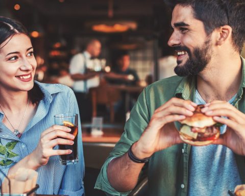 a couple eating hamburgers in a restaurant