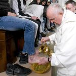 Pope Francis washing the feet of a faithful just like Christ washed the feed of his disciples