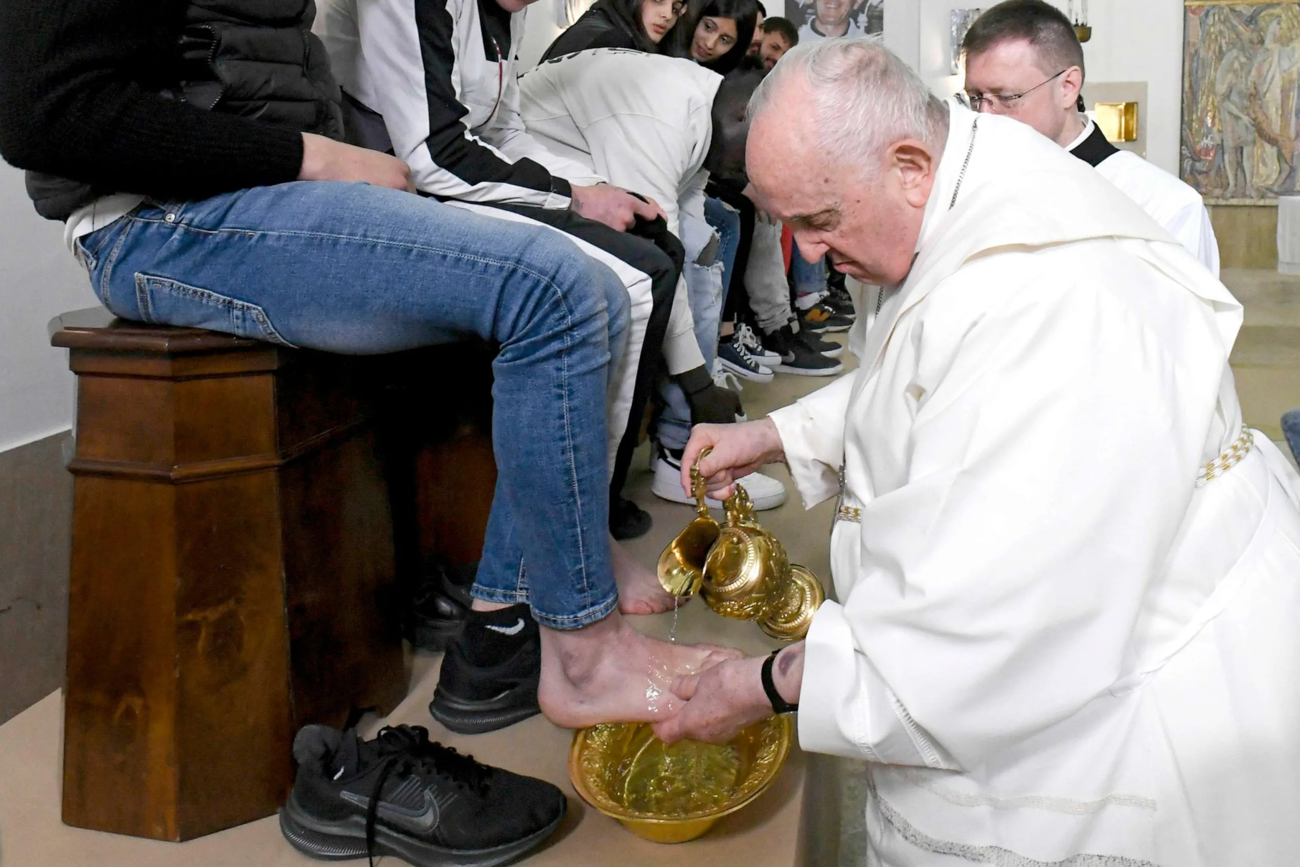 Pope Francis washing the feet of a faithful just like Christ washed the feed of his disciples