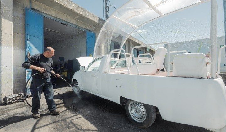 Men work on turning the popemobile into a health clinic (Caritas )