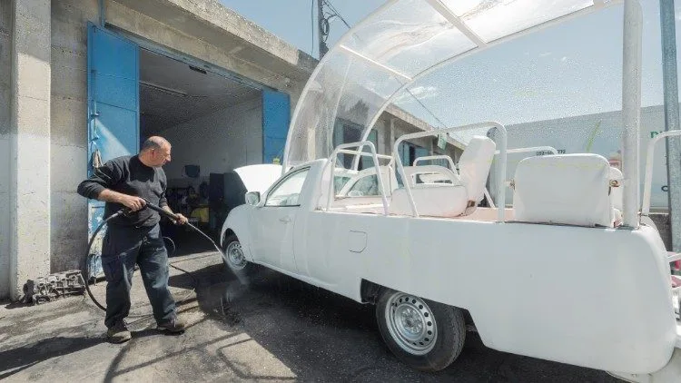 Men work on turning the popemobile into a health clinic (Caritas )